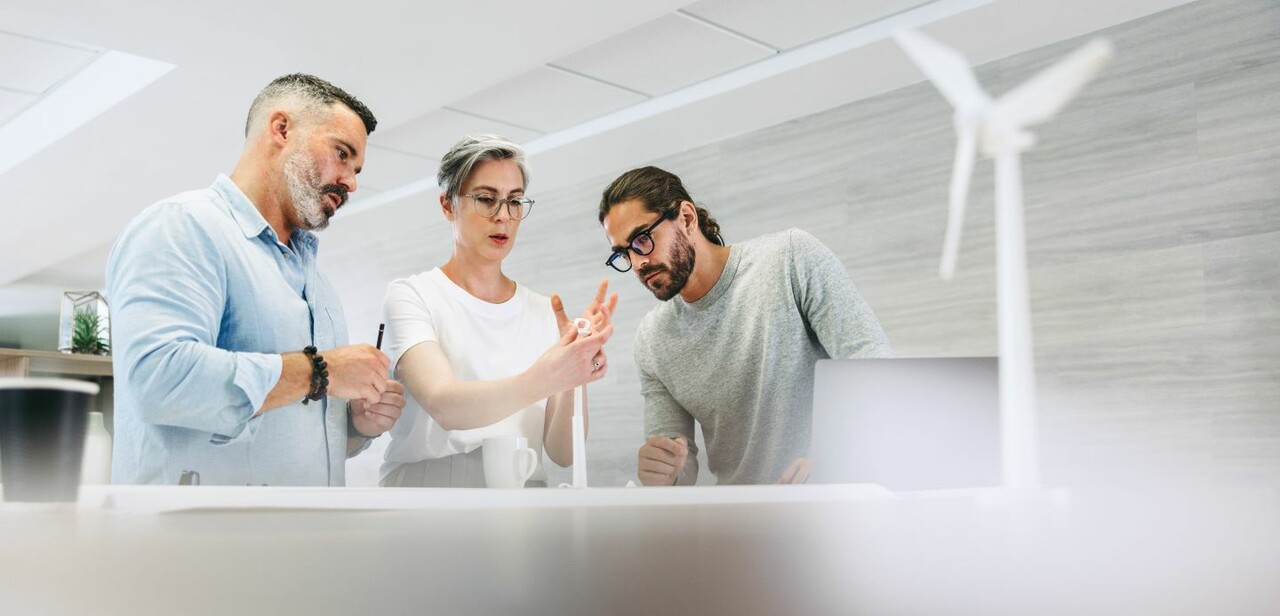 three persons working in a tech office setting three persons working in a tech office setting